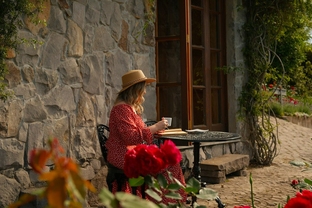 Woman writing in a notebook at a café table